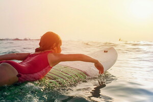 Camping lou pignada le surf pour débutant on répond à toutes vos questions Ça veut dire quoi ramer quand on commence le surf fillette ramant dans l'eau sur sa planche au sunset