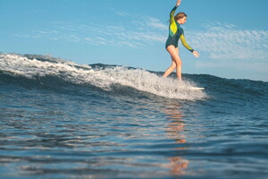 Camping lou pignada le surf pour débutant on répond à toutes vos questions S'entraîner régulièrement pour progresser rapidement fille surfant la vague sur une planche avec combi neoprene